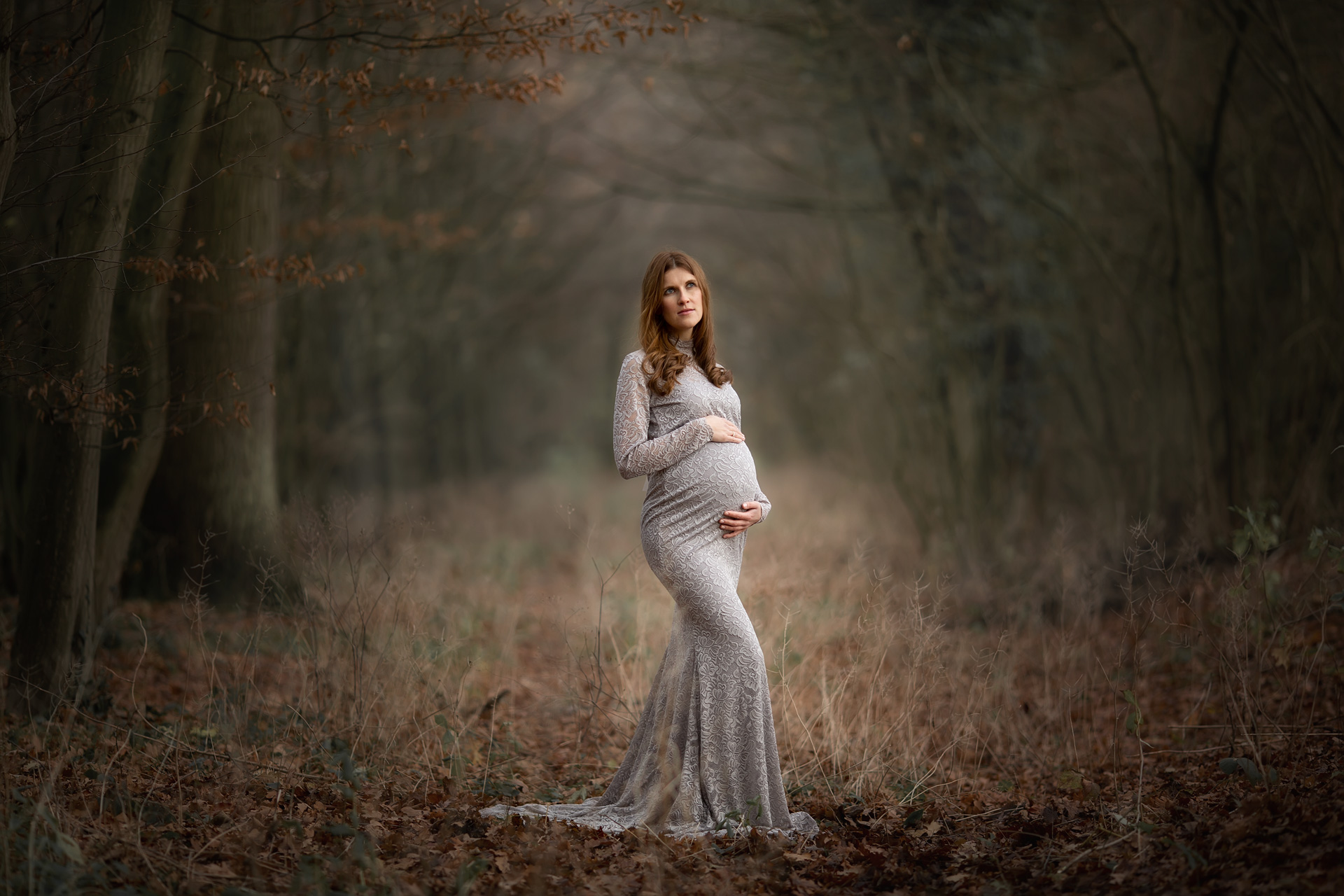 Babybauchshooting im grauen Kleid auf dem Waldweg Babybauchshooting im Wald